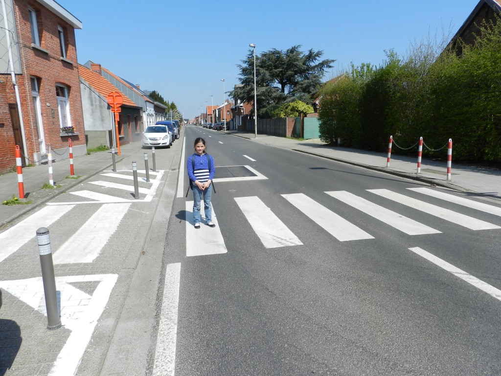 Een kind (dat zijn naam niet mag noemen) demonstreert in de Dorpsstraat te Berendrecht hoe het moet oversteken vlak voor het 'verkeersvlak'.  ouders 